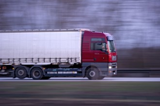 Unconcentrated driver in truck, lorry, semi-trailer MAN TGA 26.440 driving fast on the A92