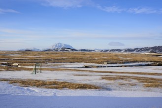 View over snow-covered football playground towards Mt. Herdubreid, winter, farm Mödrudalur, located