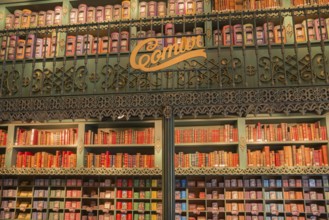 A shop with high shelves filled with books and tins of sardines, decorated in a nostalgic style