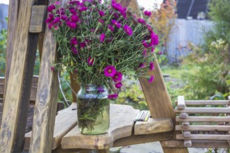 A bouquet of asters in a glass jar