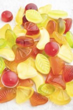 Various fruit jelly candies on gray concrete background. side view, close up