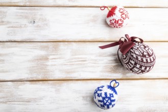 Christmas or New Year composition. Decorations, knitted balls, on a white wooden background. Top