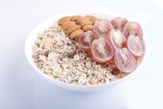 A plate with muesli, almonds, pink grapes isolated on a white background. close up