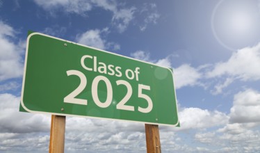 Class of 2025 green road sign over clouds and blue sky