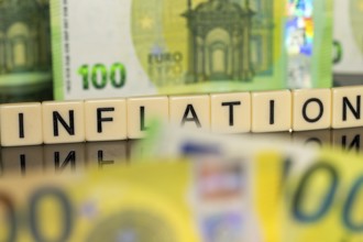 Symbolic image of inflation: euro banknotes and letter cubes showing the word inflation