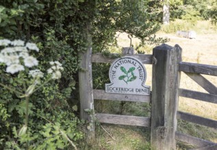 National Trust sign at an entrance to Lockeridge Dene, near Marlborough, Wiltshire, England, UK