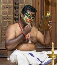 Kathakali dancer applying make-up, Fort Kochi, Cochin, Kerala, India, Asia