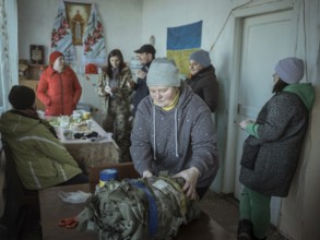 Women packing camouflage nets during a birthday party in the frontline village of Shevchenkove,