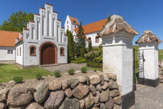 Lindelse Kirke, typical Danish church from 1830, whitewashed, red tiled roof, hill, entrance gate,