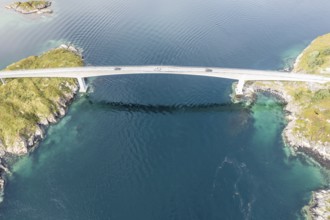 Aerial view of bridge connecting islands at the norwegian coast, cars on the one lane bridge,