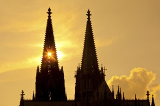 The sun shines through one of the two towers of Cologne Cathedral, Cologne, Rhineland, North