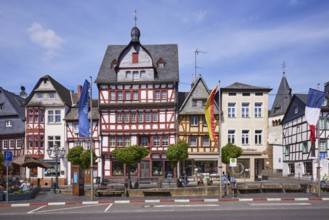 Multi-storey half-timbered houses, Adenau Markt bus stop and flags on the main street in Adenau,