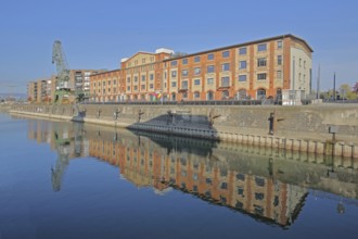 Old wine warehouse with harbour crane, quay and reflection, quay wall, harbour, gantry crane,