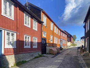 A village street with traditional red wooden houses in sunny weather, UNESCO World Heritage Site,