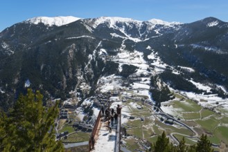 Mehrere Menschen stehen auf einem Aussichtspunkt und genießen die schneebedeckte Berglandschaft und