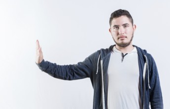 Young man making rejection gesture with palm of hand isolated. Displeased person rejecting