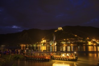 People and bicycle ferry from Rossatz and behind Dürnstein in front of the fireworks for the