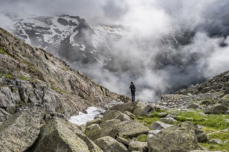 Mountaineer at a mountain stream, Furtschaglbach, cloudy mountains in the background,