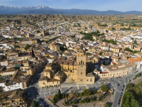 Large church and various buildings in an extensive urban landscape surrounded by mountains. Clear