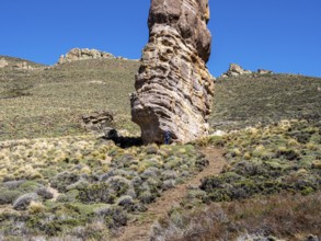 Single hiker at foot of rock formation Piedra Clavada, stand-alone rock tower, Jeinimeni NP,