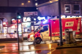 Ambulance on alarm, DRK, Essen fire brigade, rainy weather, city centre, evening, Essen, North