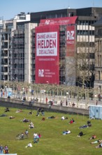 A construction company has hung a large poster on a building facade on the Rhine promenade,