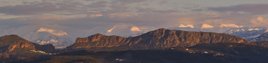 Panoramic shot, Dramatic landscape with snow-capped mountains and rock formations under a cloudy