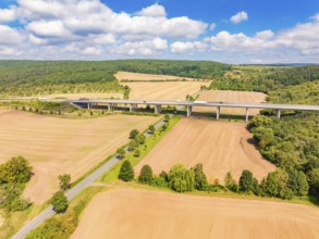 Landscape with a road and motorway bridge, surrounded by fields and trees under a blue sky, Harz