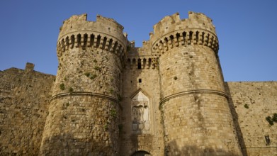 Fortress with impressive battlements and massive Tor tor under a clear blue sky, sea gate, harbour