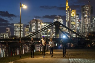 Skyline of the city centre of Frankfurt am Main, joggers on the pavement, promenade along the river