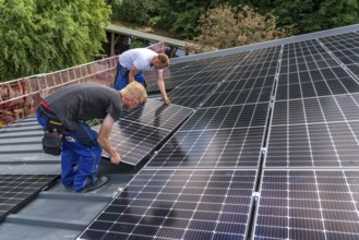 Installation of solar modules on the roof of a barn on a farm, over 210 photovoltaic modules are