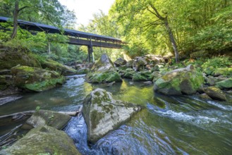 The Irrel Waterfalls, rapids in the lower reaches of the Prüm, covered wooden bridge for hikers,