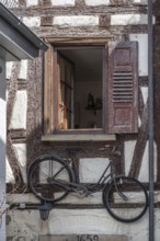 Bicycle hanging under a window of an old half-timbered house, Rottenburg, Baden-Württemberg,