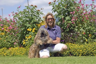 Woman takes Lhasa Apso for a walk in the park