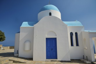 White-blue church with clear architectural forms under a bright blue sky, Church of Profitis Ilias,