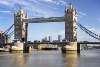 Historic Tower Bridge with twin towers over the River Thames under a clear sky, surrounded by city