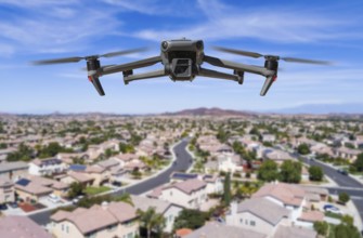 Unmanned aircraft system (UAV) quadcopter drone in the air over residential neighborhood.