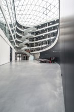 Large atrium with futuristic architecture, glass roof and a car on the edge, University of