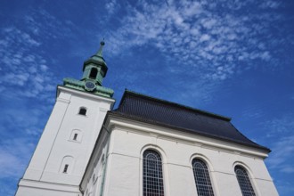 Church with tower, blue sky and light clouds, white facade and green roof, Bergen, Vestland,