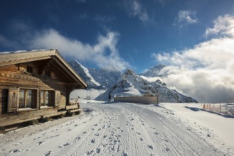 Wooden chalet and ski slope, with views of the Eiger, Mönch and Tschuggen, Grindelwald, Bernese