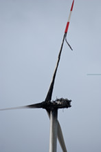 Damaged wind turbine, wind turbine, rotor blades and generator are burnt, fire, fire, grey sky,