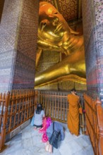 Reclining Buddha with praying monk in Wat Pho temple, Buddhism, religion, world religion,