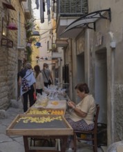 A pasta maker at work in the famous Strada del Orecchiette, historic centre of Bari Vecchio,