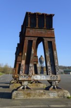 Rusty steel structures with graffiti in front of a clear blue sky in an abandoned industrial