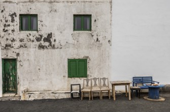 Weathered building with green shutters and old outdoor furniture, Canary Islands, Lanzarote, Spain,