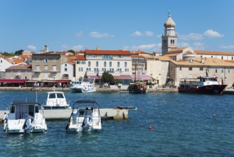 Various boats dock at the waterfront, with buildings and a bell tower in the background, Old Town,