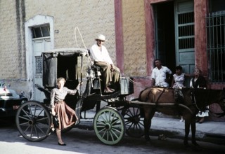 Female tourist in front of the Surrey horse-drawn carriage, Mexico, around 1961, Central America