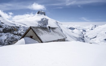 Snow-covered mountain landscape with snow-covered hut, Bernese Alps, Bernese Oberland, Switzerland,