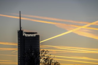 Condensation trails from aircraft flying at high altitude, evening sky, after sunset