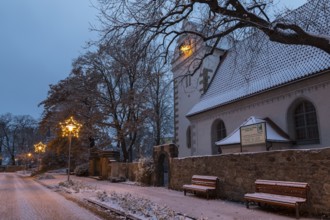 Old church with illuminated poinsettia, snowy and at dusk, Coswig, Saxony, Germany, Europe